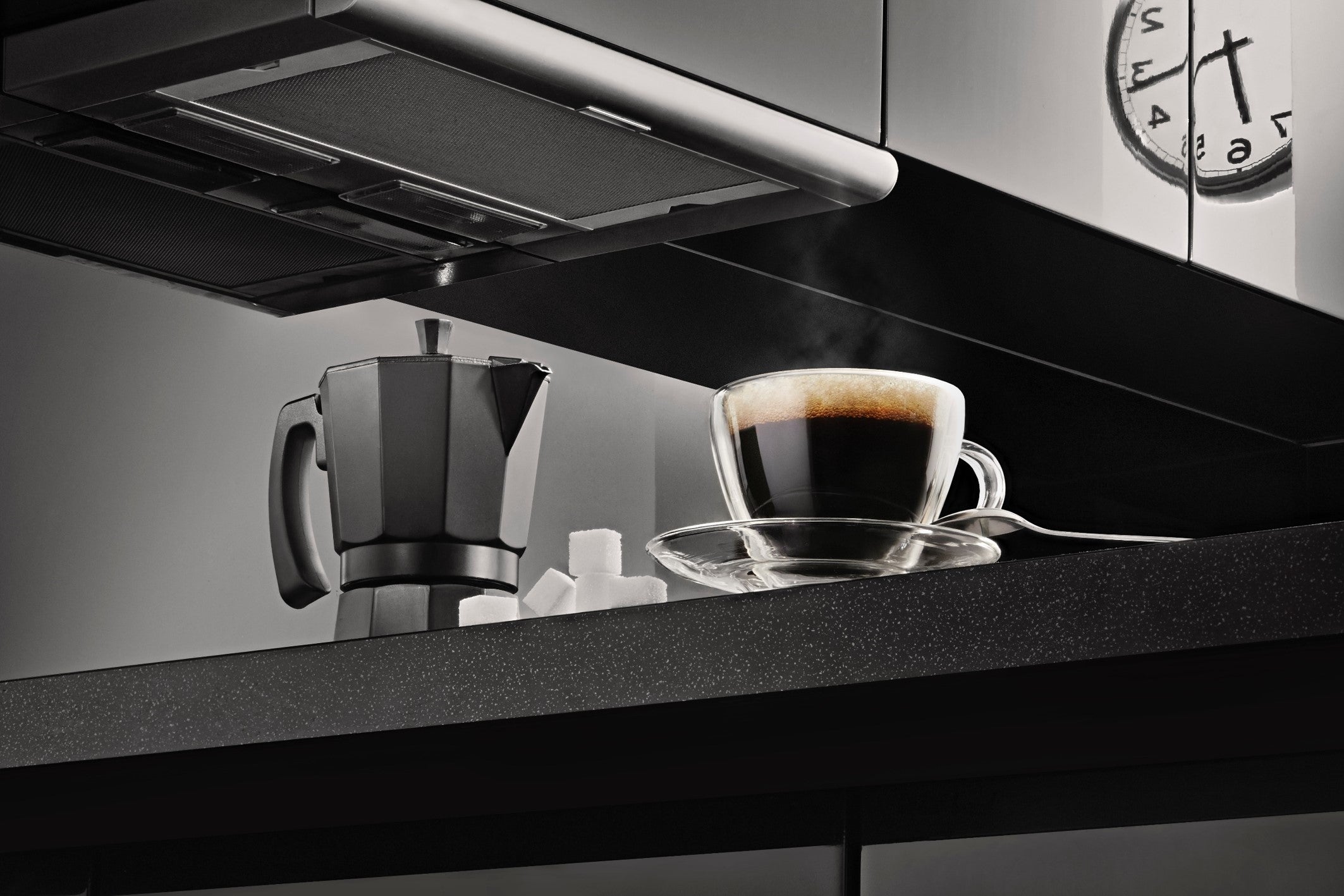 siyah tezgahın üzerinde siyah moka pot ve kahve fincanı