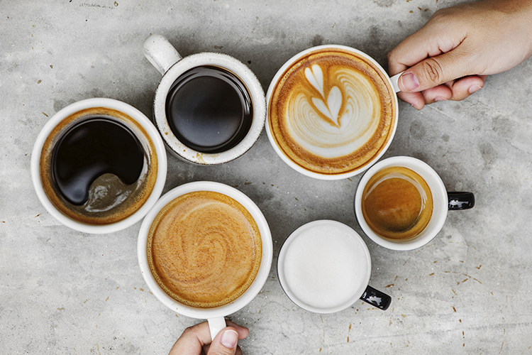 gri masa üzerinde iki elin de olduğu espresso, amerikano, latte, cappucino, ristretto