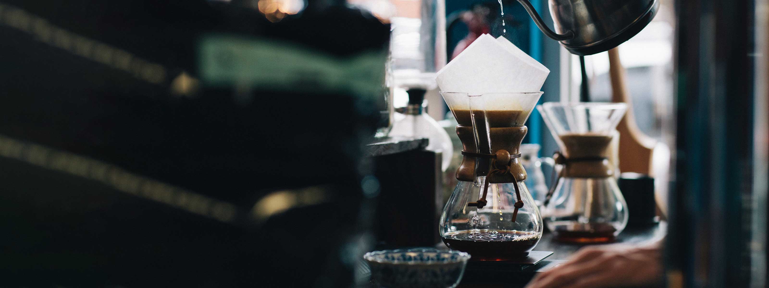 Chemex, bariste kettle ve diğer filtre kahve demleme ekipmanlarının uzak açıdan çekildiği bir görsel.