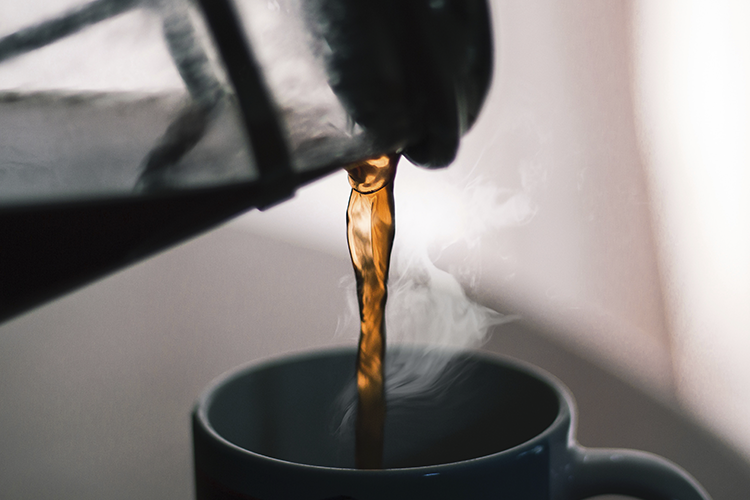 French Presste demlenmiş filtre kahve siyah kupaya dökülüyor